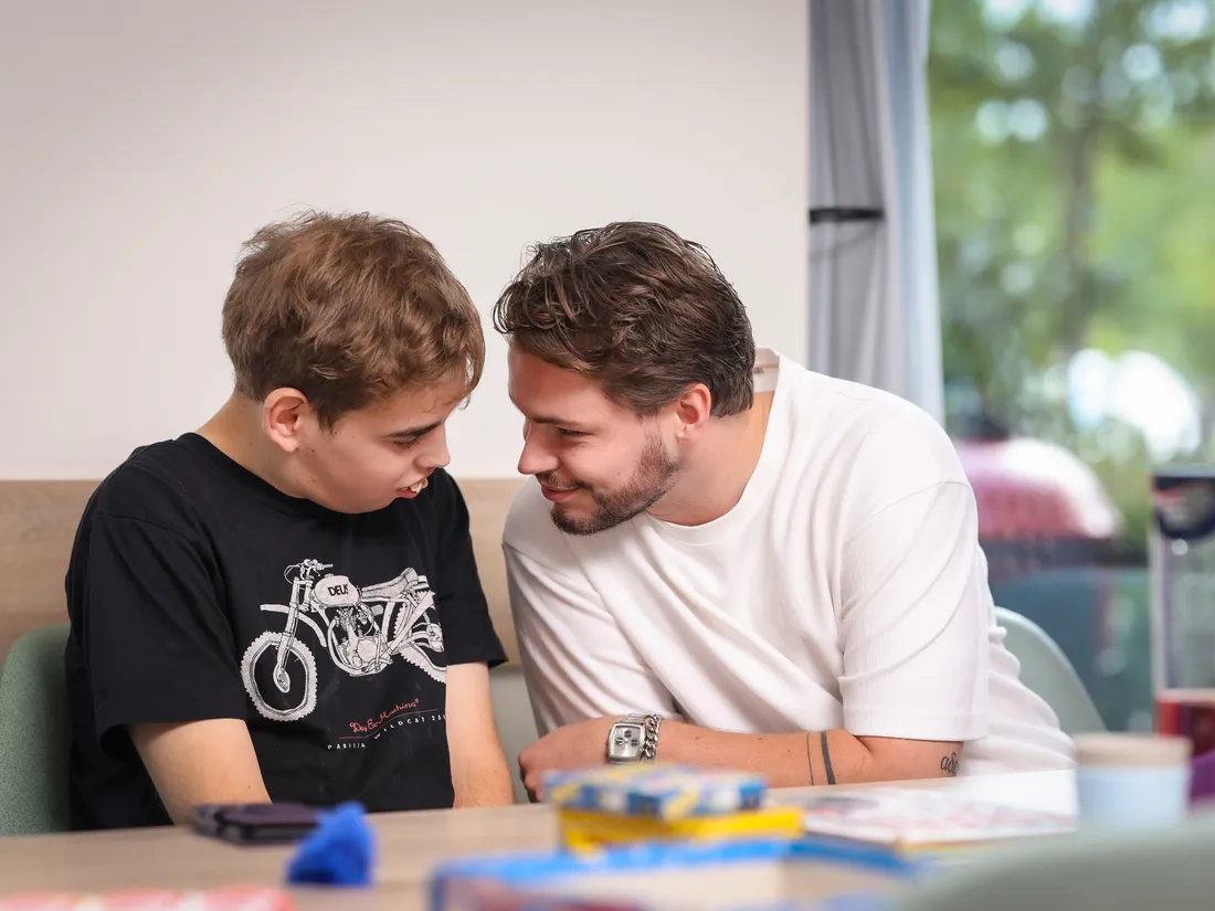 Begeleider en bewoner aan tafel bij Stichting ZorgWiel